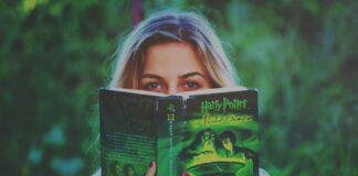 Kobieta czyta książkę o Harrym Potterze w zielonym parku
