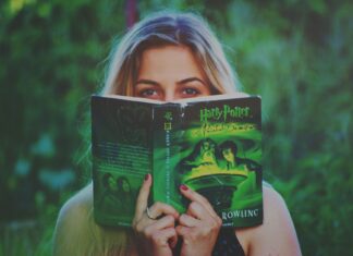 Kobieta czyta książkę o Harrym Potterze w zielonym parku