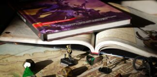 Zbliżenie na stół do RPG z mapą, podręcznikami, kośćmi i figurkami