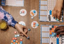 Deckbuilding, push your luck i area control: wytłumaczone na przykładach konkretnych gier Gracze przy drewnianym stole podczas strategicznej gry planszowej z drinkami